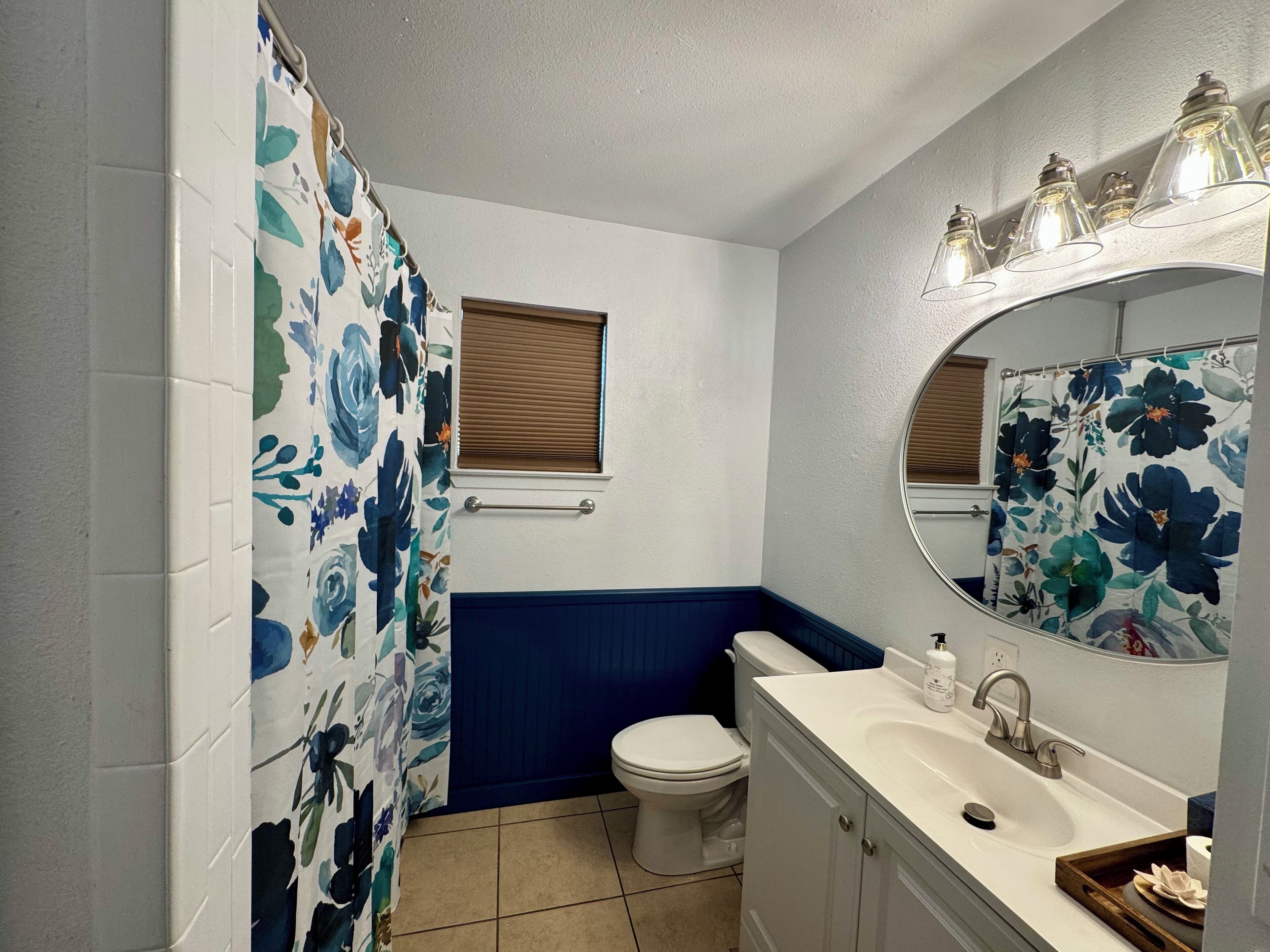 A bathroom with a toilet, sink, and shower curtain.