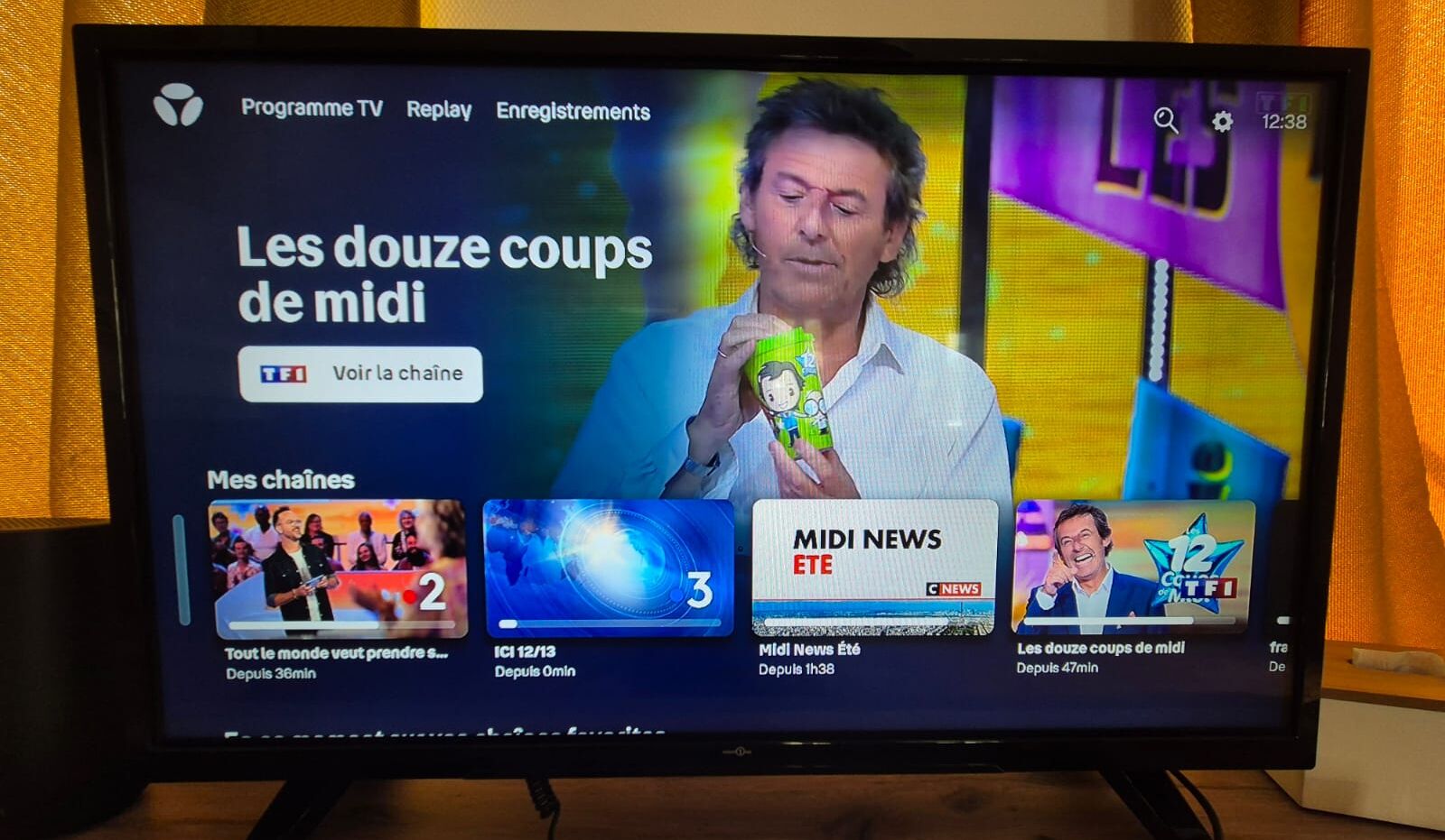 A television screen displaying a news channel interface with various program options and a prominent news ticker.