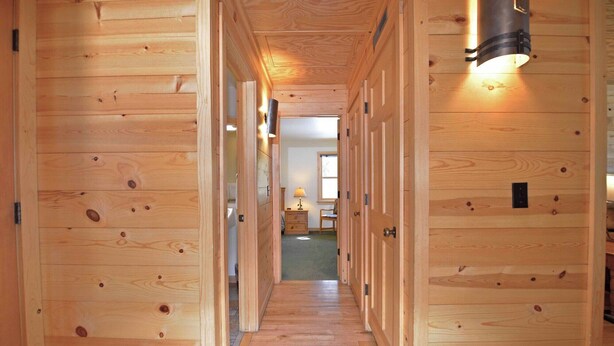 A wooden hallway with doors leading to rooms. - Rustic One Bedroom Cabin (Mazama)