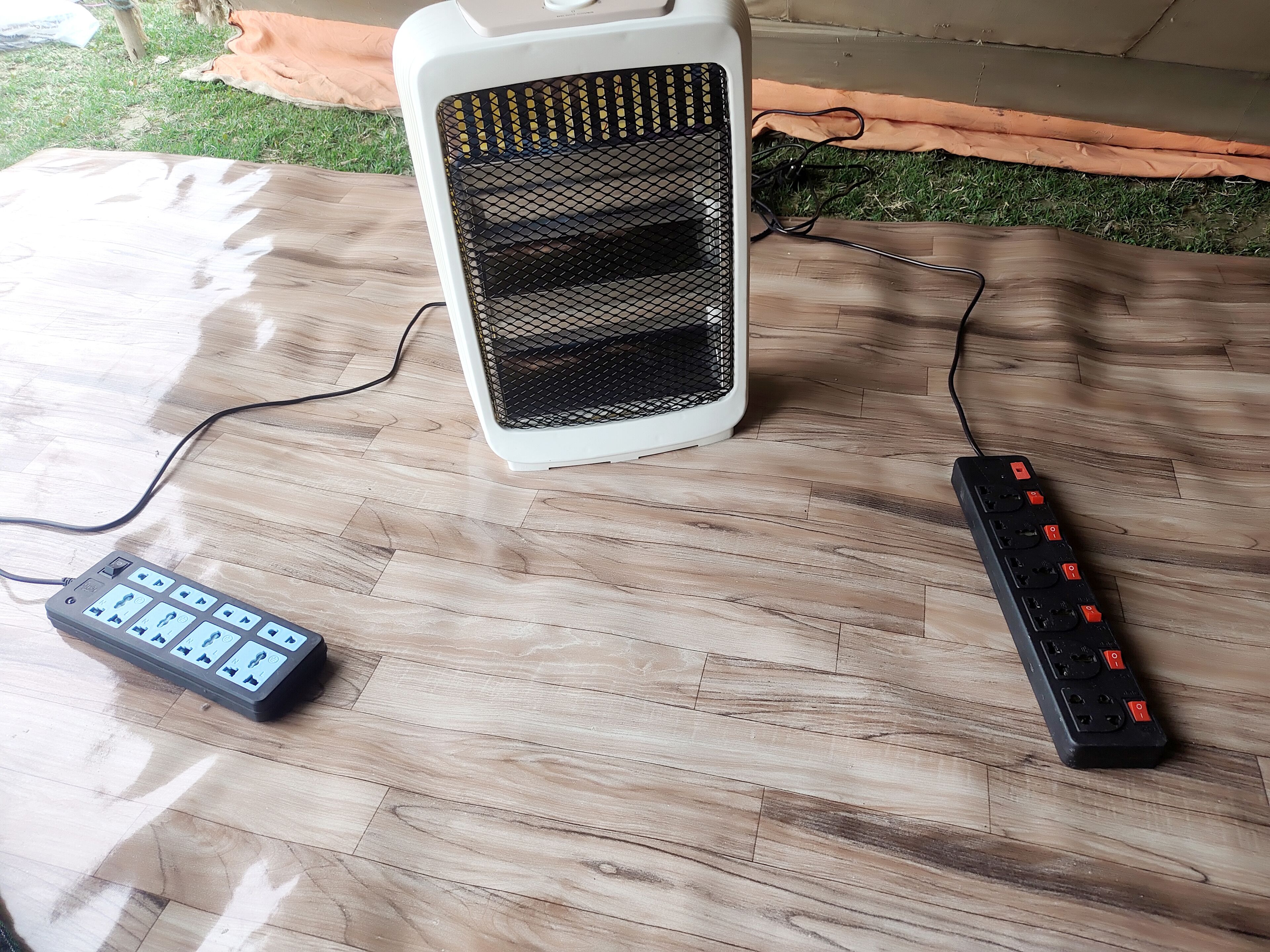A wooden floor with a white speaker and a black remote control.
