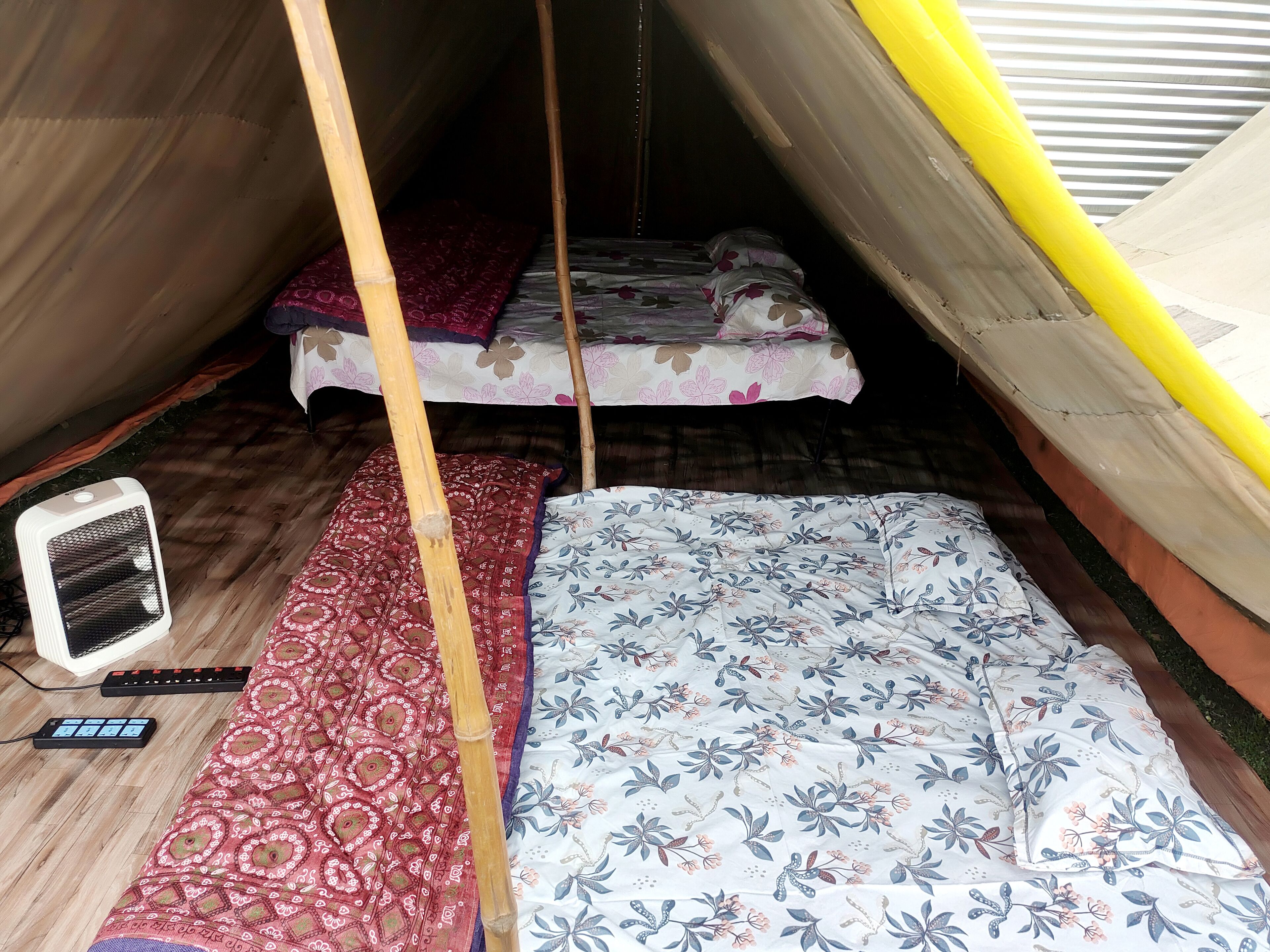 Ein kleiner, abgeschlossener Raum mit einem Bett, einem Heizgerät und einer Steuerung.