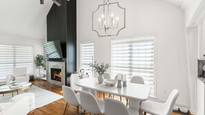 A modern dining room with a fireplace, white furniture, and a chandelier. - Luxury Retreat & Heated Pool Downtown Simpsonville (Simpsonville)