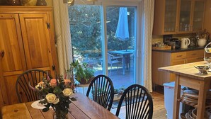 A wooden dining table with chairs, a vase of flowers, and a woven placemat. - Beautiful Nantucket summer escape,  3 bed house, quiet office, central location  (Nantucket)