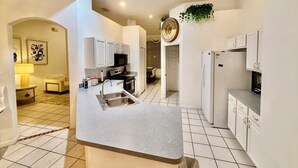 A modern kitchen with white cabinets, a built-in microwave, and a sink.