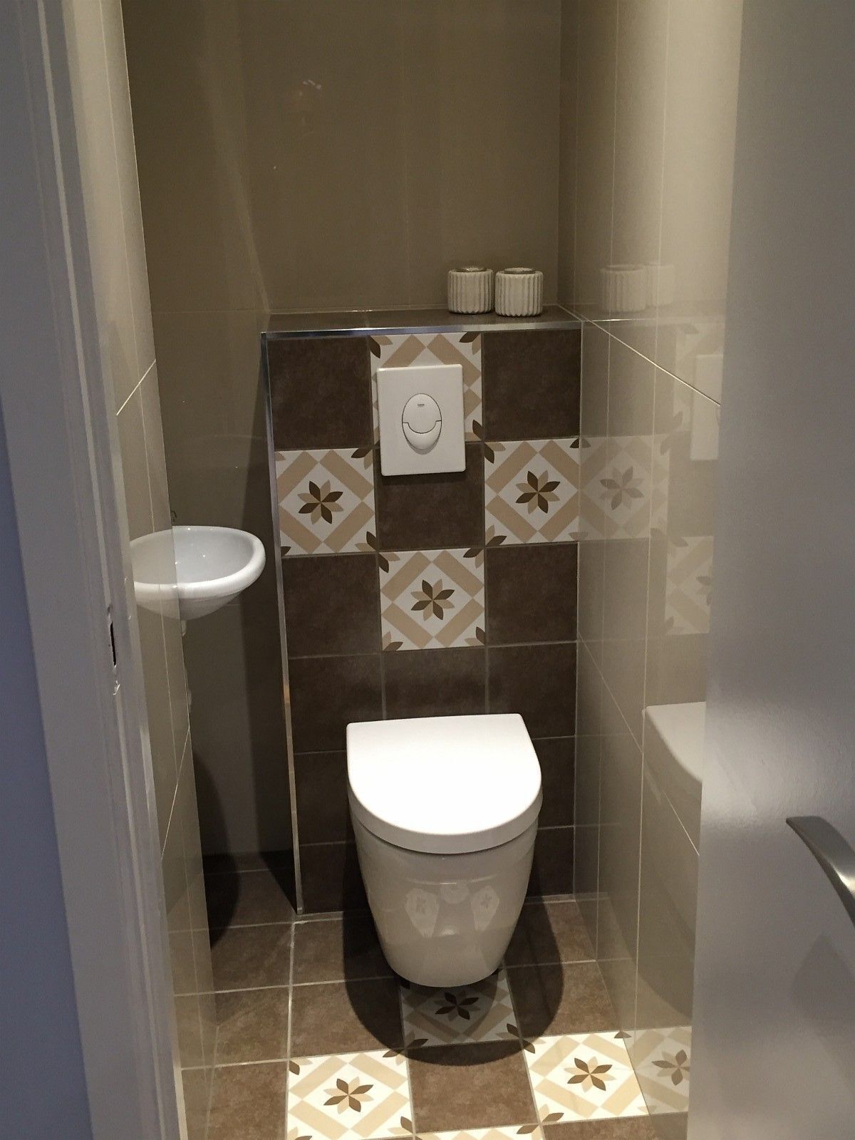 A small bathroom with a toilet, a sink, and a shower area.