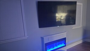 Un dormitorio con cama, televisor integrado y acuario.