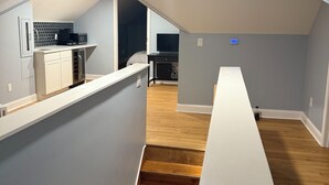 Un apartamento moderno con cocina, comedor y una escalera que sube a un nivel superior.