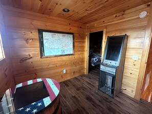 Experience a cozy cabin stay with a map on the wall, a small table, and a television set.