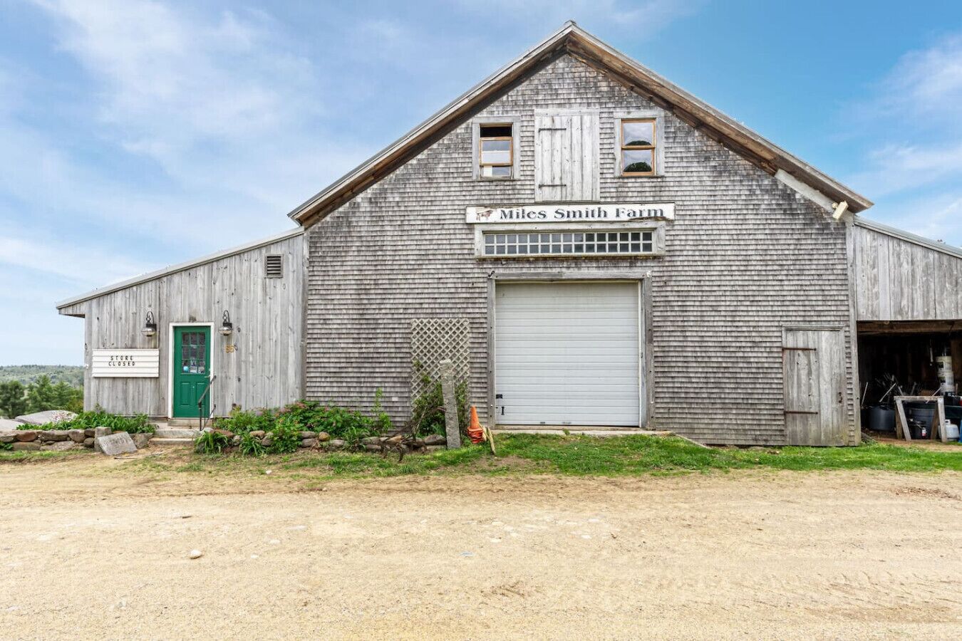 A rustic barn with a green door, a closed sign, and a nameplate reading "Miles Smith Farm."