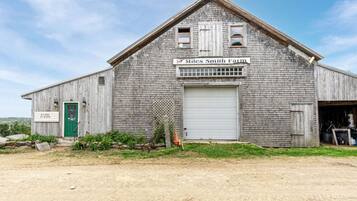A rustic barn with a green door, a closed sign, and a nameplate reading "Miles Smith Farm."