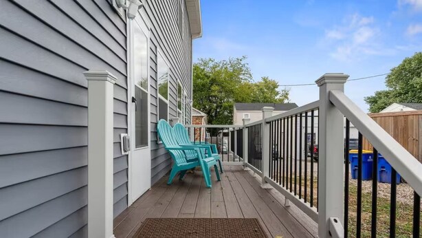A wooden deck with a white railing, a blue Adirondack chair, and a doormat. - Townhouse near WKU & Mammoth Cave (Bowling Green)
