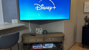 A flat-screen TV mounted on a wall displaying the Disney+ logo. - Custer Cottage / Fenced Yard (Billings)