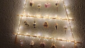 A decorated Christmas tree with lights and ornaments against a textured wall. - Welcoming, cosy 4-bedroom, pet-friendly cottage in Bakuriani (Bakuriani)