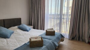 A neatly made bed with blue pillows and two wicker baskets on a blue bedspread. - Welcoming, cosy 4-bedroom, pet-friendly cottage in Bakuriani (Bakuriani)