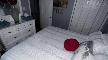 Ein Schlafzimmer mit einem Bett, einem Schminktisch und einer Tür mit Namensschild.