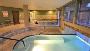 A pool area with a glass barrier, a staircase leading to a door, and a view of the outside through large windows. - Cozy Condo, 3 beds, 2 baths, kitchen, near RMNP, Hiking, Golf, Skiing and more! (Granby)
