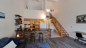 Un apartamento moderno con cocina, comedor, escaleras y sala de estar.