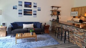 Una sala de estar moderna con sofá, una mesa de centro y una obra de arte en la pared.