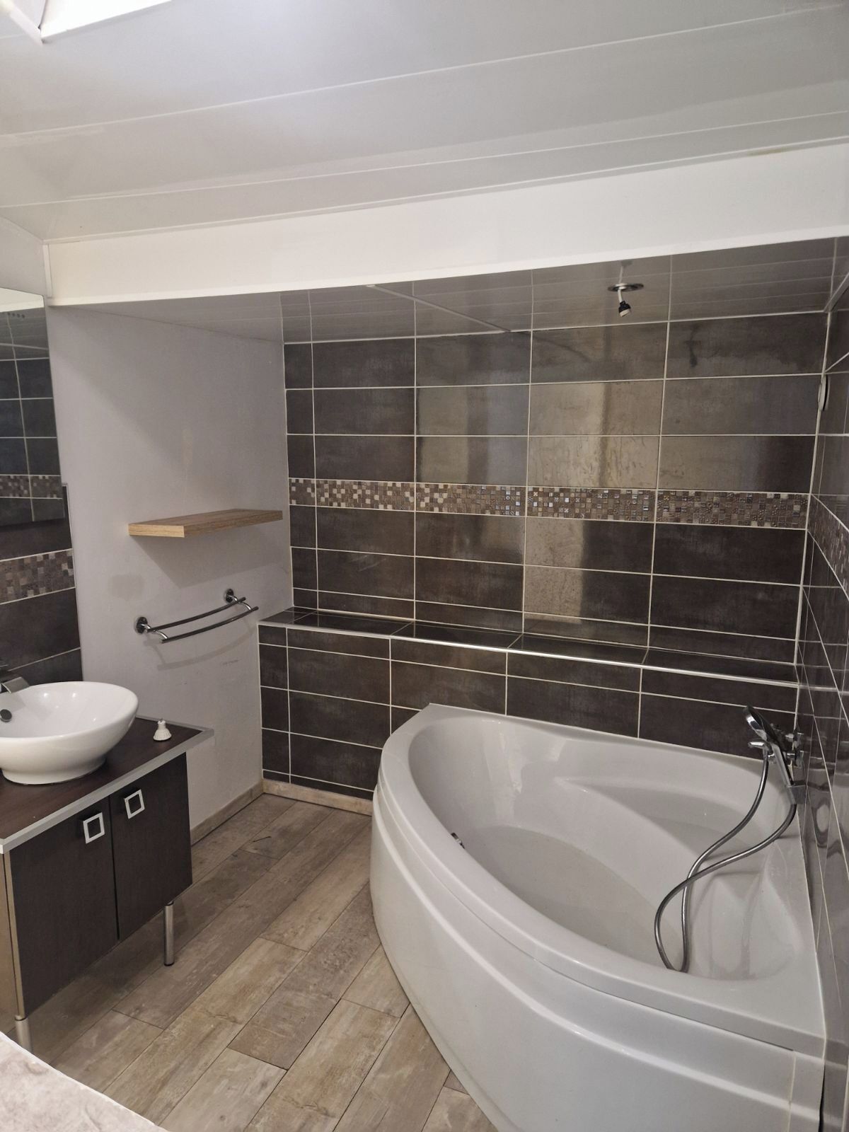 A modern bathroom with a freestanding bathtub, a vanity with a sink, and a mirror.