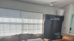 A room with a sofa bed, a dark storage unit, and a window with blinds. - 5 Minute Walk to Beach, Restaurants, Shops,Playground. Quaint and Quiet in IRB ! (Indian Rocks Beach)