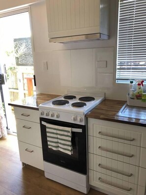 Microondas, placa de cocina, cafetera o tetera y utensilios de cocina