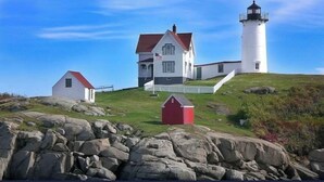 A lighthouse and a white house with a red roof on a grassy hill. - Cozy 2 BR house in gated community 1 mile from Wells/Ogunquit beaches/shops  (Wells)