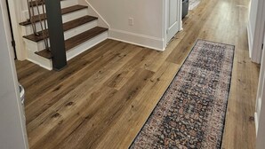 A modern interior with a wooden staircase, a fireplace, and a patterned rug. - New lakefront 3 bedroom, 2 story house in lovely Georgetown with private dock (Georgetown)