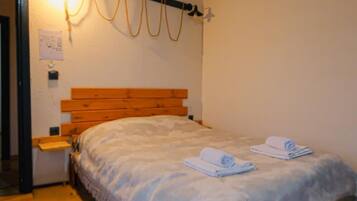 Une chambre avec un lit en bois, un tapis à motifs et un plafond en bois.
