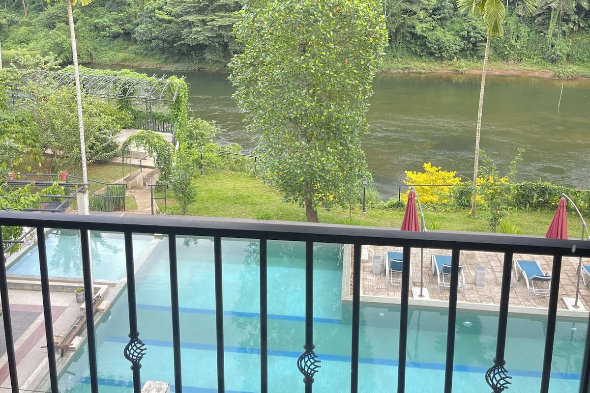 Un espace piscine offrant une vue sur une rivière et la végétation environnante.