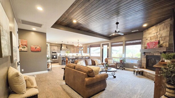 A spacious living area with a fireplace, a kitchen in the background, and a ceiling fan. - Guest favorite near Zion/Epic view/Pickleball/Pool (Kanab)