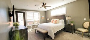 A bedroom with a bed, bedside tables, a chair, a desk, a ceiling fan, and a window with blinds. - Guest favorite near Zion/Epic view/Pickleball/Pool (Kanab)