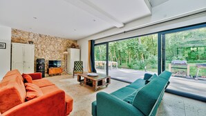 A modern living room with a stone wall, a large window, and a view of the outdoors.
