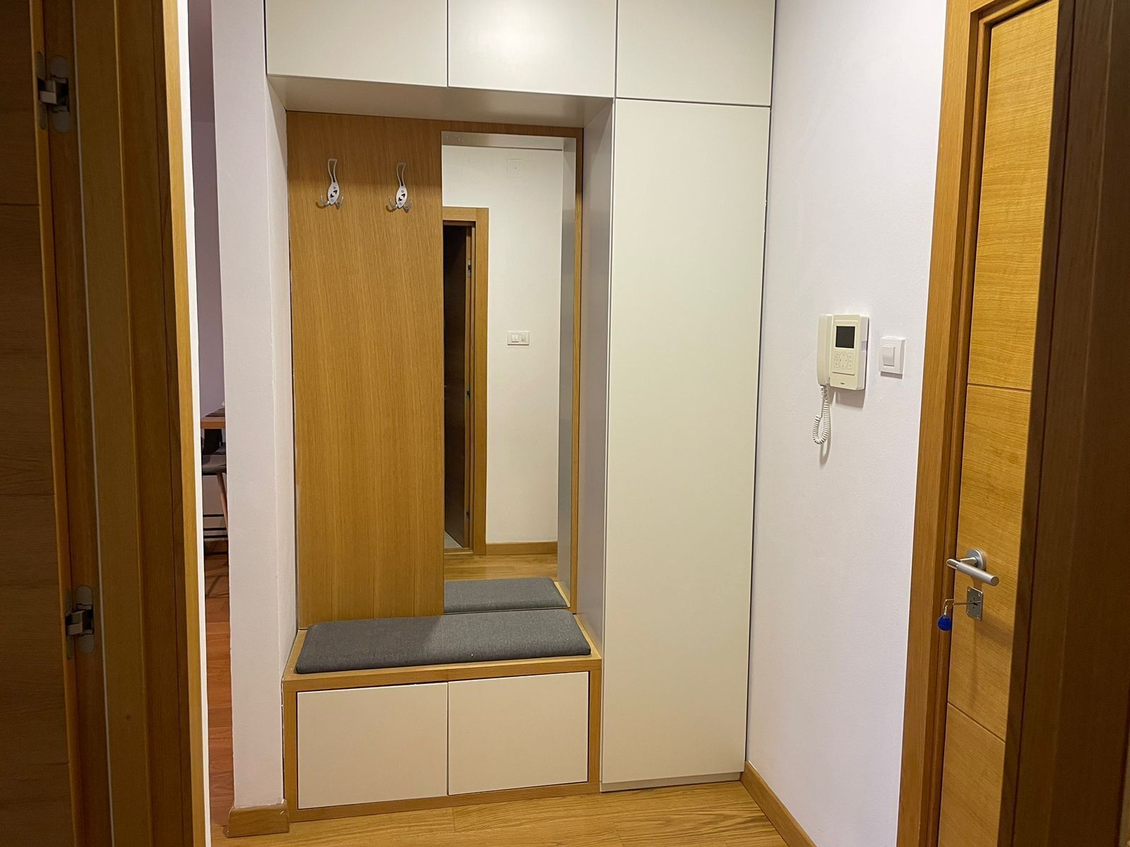Ein kleiner Raum mit integriertem Sitzplatz, Kleiderschrank und Telefon.