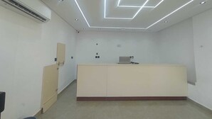 Een receptie met een bureau, een airconditioner en een aan de muur bevestigde telefoon.