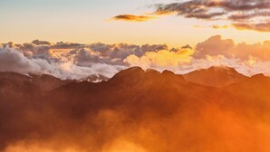 Een bergketen met wolken bij zonsopkomst of zonsondergang.