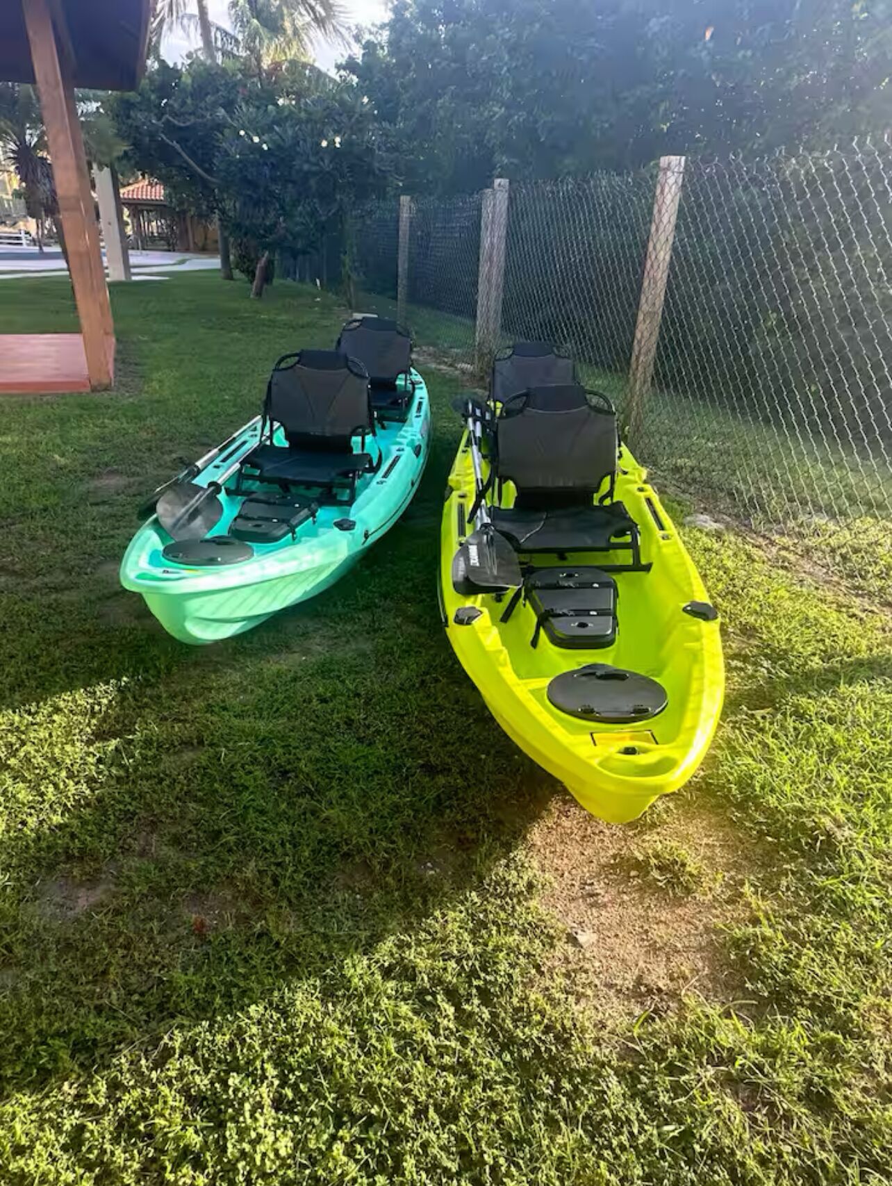 Due kayak su un'area erbosa con una recinzione sullo sfondo.