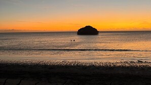 A beach at sunset with a small island in the distance and a crescent moon in the sky. - Sol y Mar - Oceanfront Condo! (Cabo Rojo)