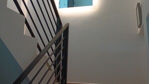 A staircase with a black railing and a small illuminated window at the top.