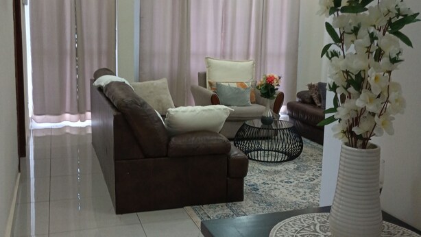 A modern living room with a sofa, a coffee table, and a decorative vase.