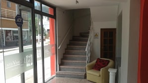 A hotel lobby with a staircase, a sofa, and a column. - Buenavista Hotel (La Falda)