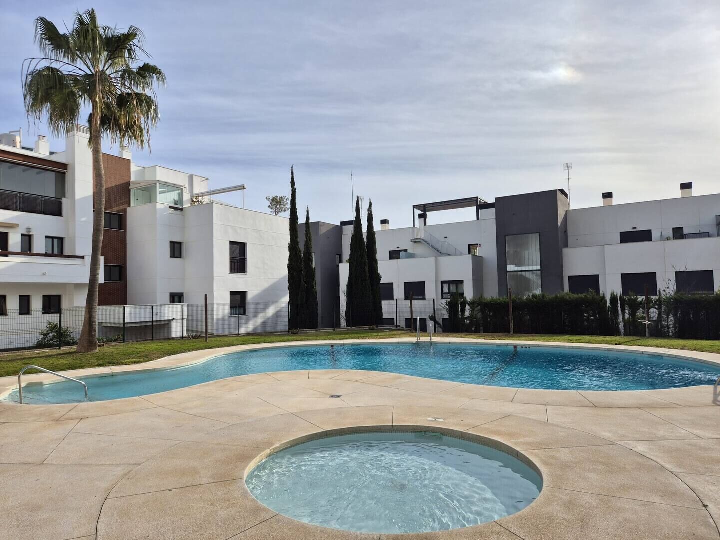 A modern apartment building with a swimming pool and a hot tub.