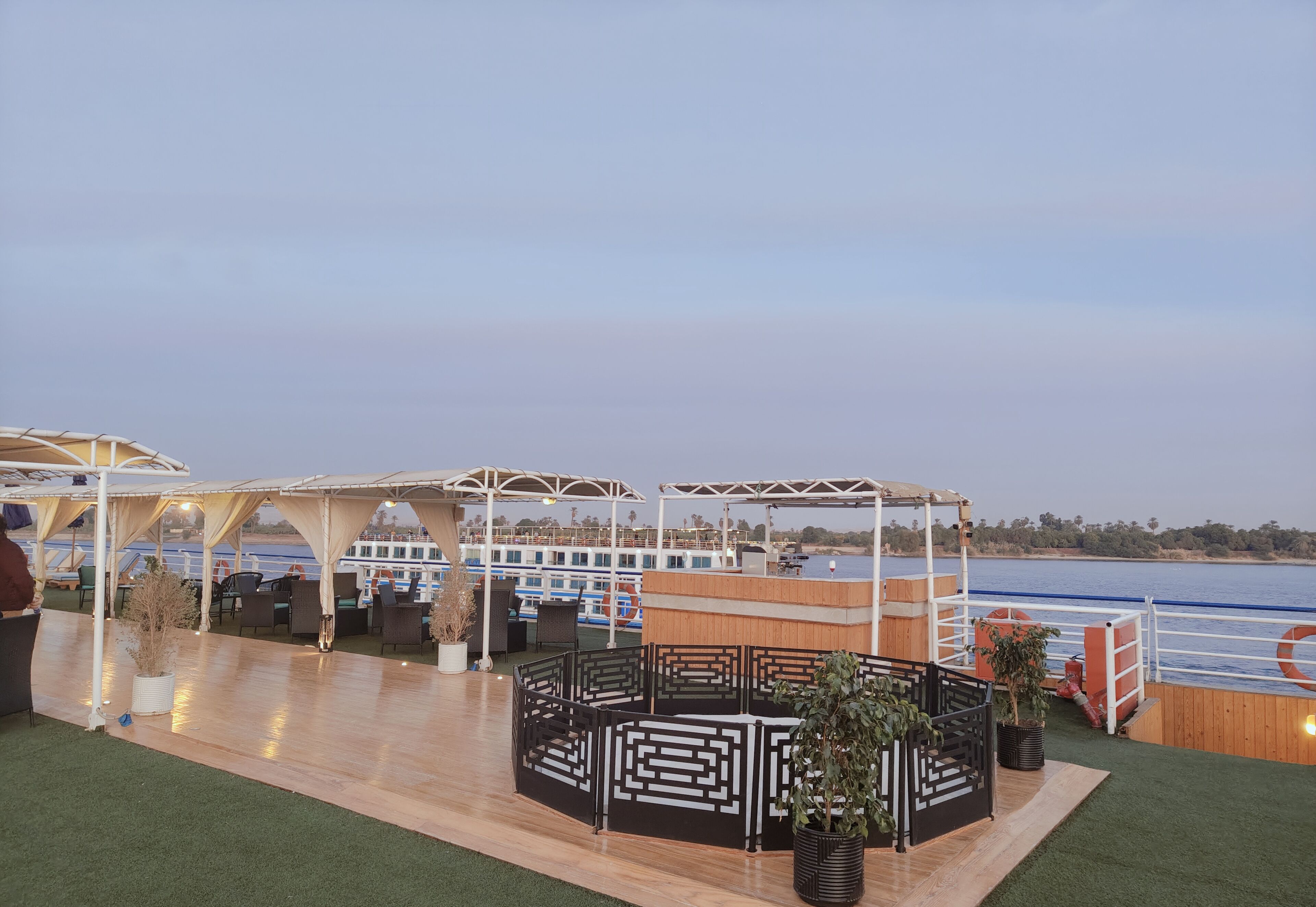 Una terraza con asientos y vista al agua.