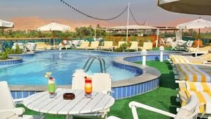 حمّام سباحة خارجي، مظلات على حمّام السباحة، مقاعد للتشمس