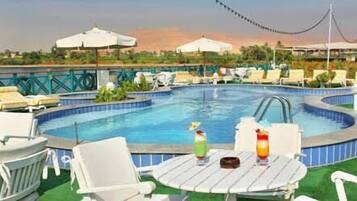 Una piscina al aire libre, sombrillas, tumbonas