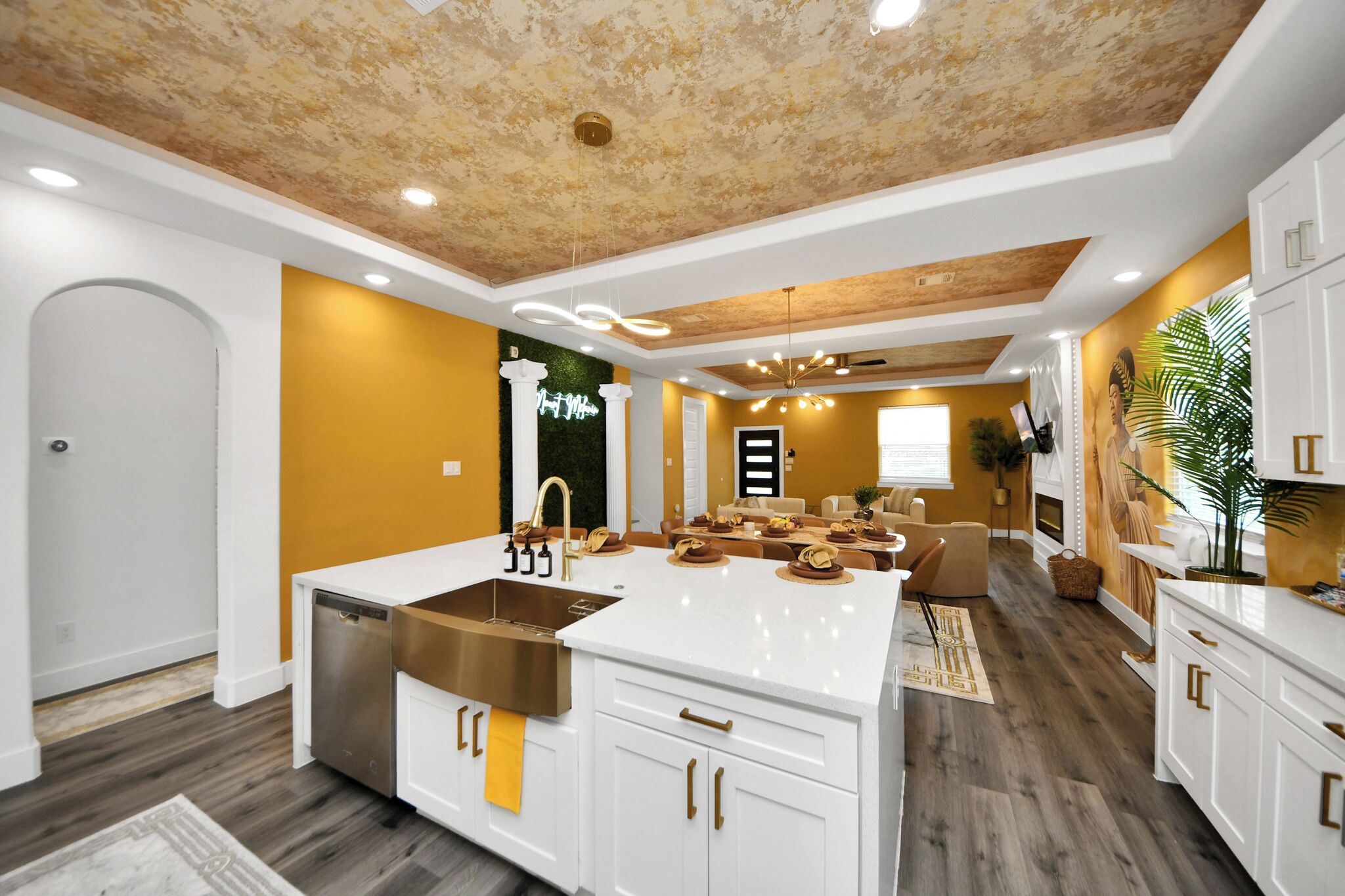 Une cuisine moderne dotée d’un îlot central, de meubles blancs et d’un plafond en bois.