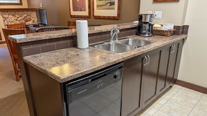 Una cocina con encimeras de granito, electrodomésticos de acero inoxidable y lavavajillas.