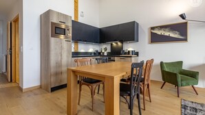 A modern kitchen with dark cabinets, a wooden dining table, and chairs.