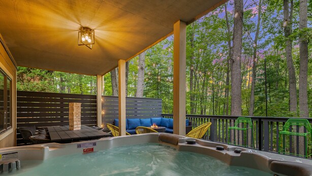 Un espace avec un bain à remous, des sièges et une vue sur une forêt.
