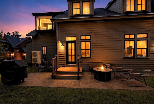 A house with a patio, outdoor seating, and a fire pit.