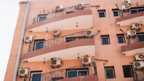 A multi-story building with balconies, air conditioning units, and a simple architectural design. - Hotel Appart Larabi (Marrakech)